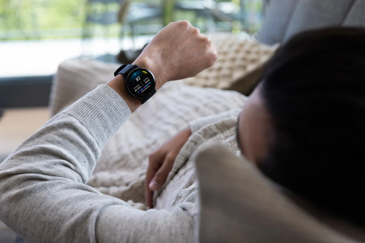 man at the sofa checking smartwatch